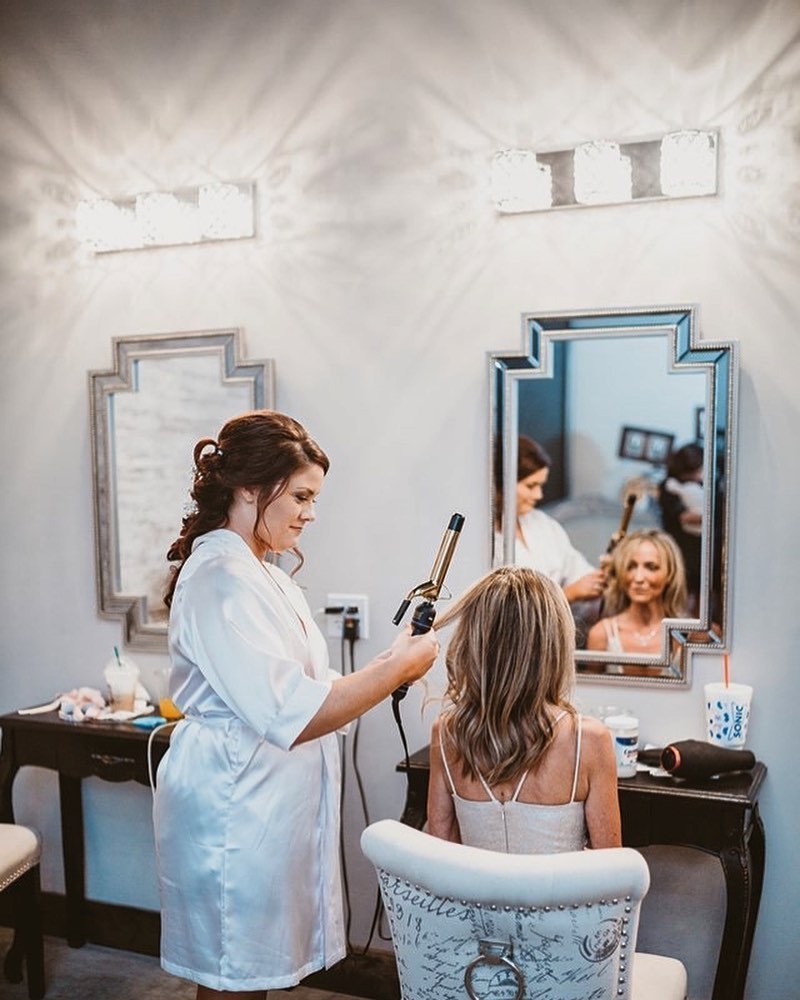 bridesmaid curling bride's hair