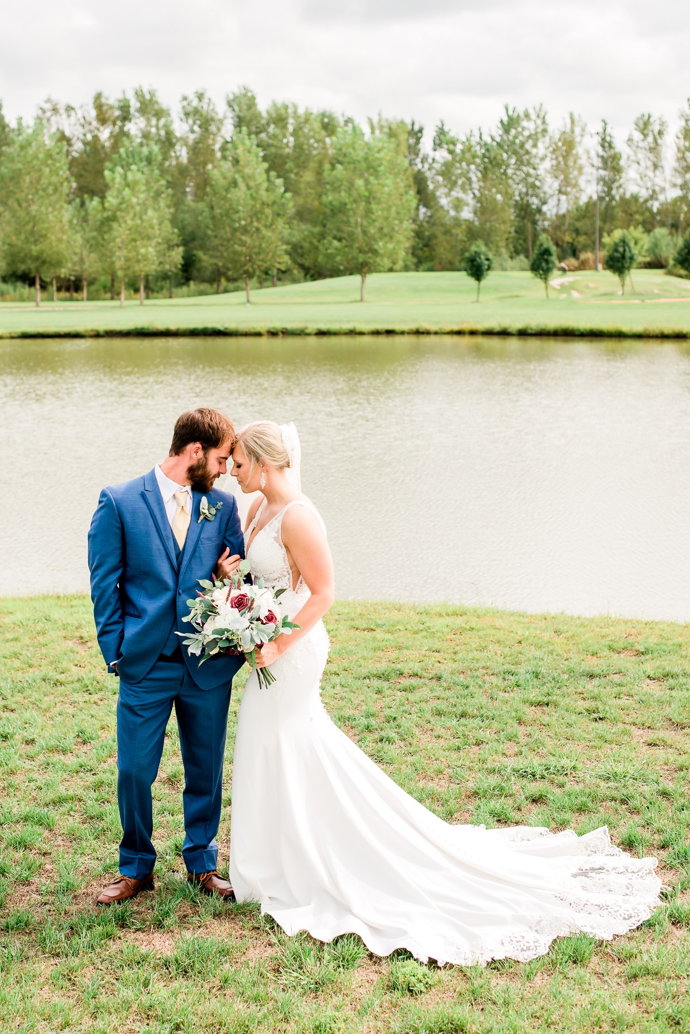 bride and groom next to pond