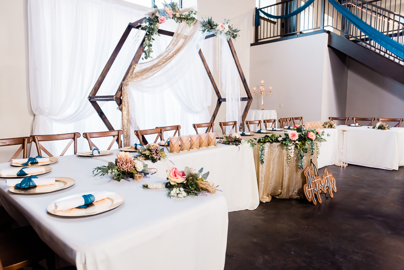 wedding party table at reception in front of hexagon arch