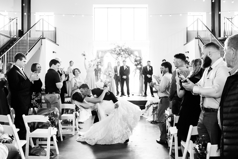 bride and groom kissing in aisle