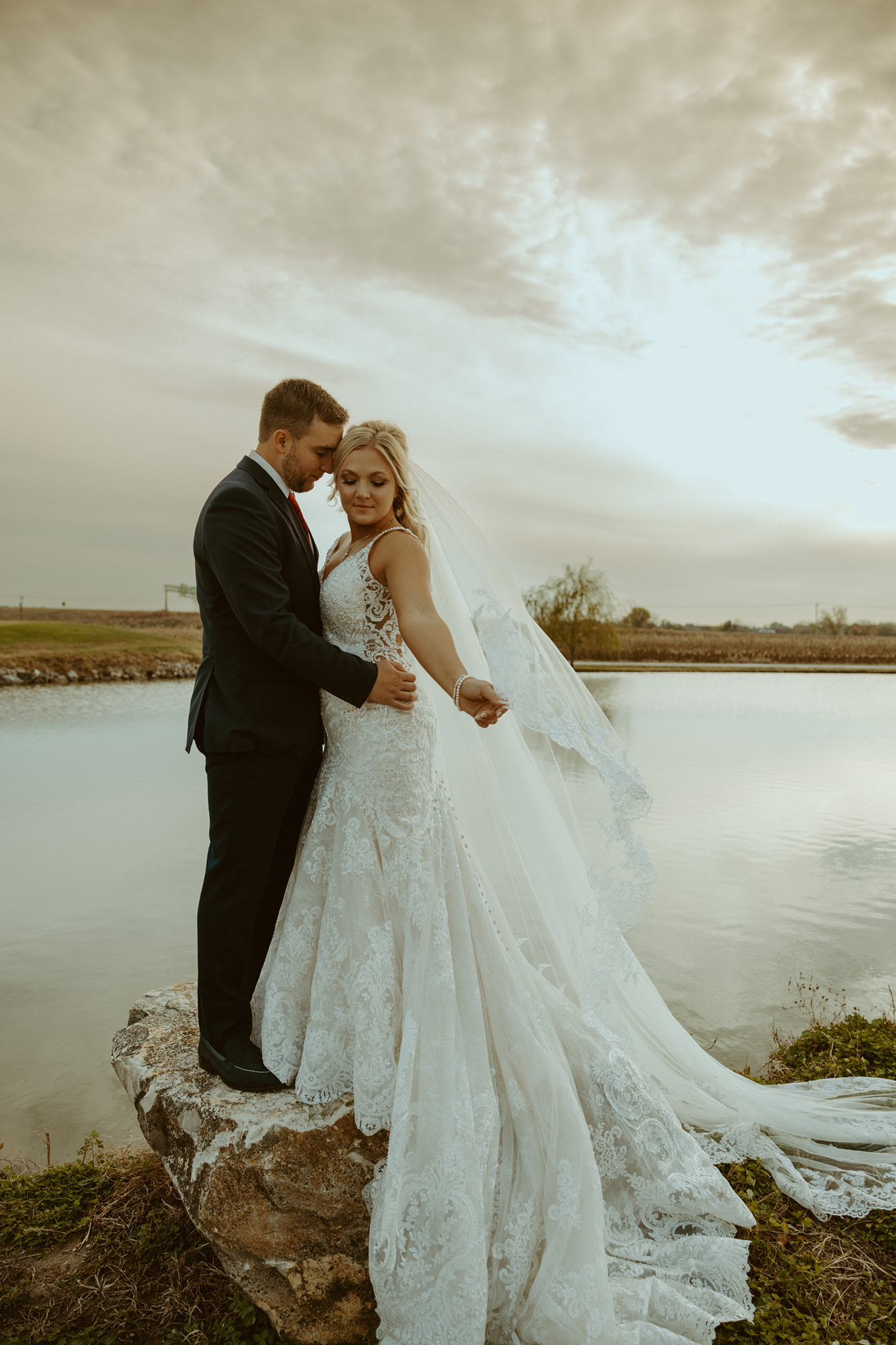 couple embracing next to pond