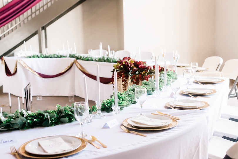 table with greenery runner and gold place settings