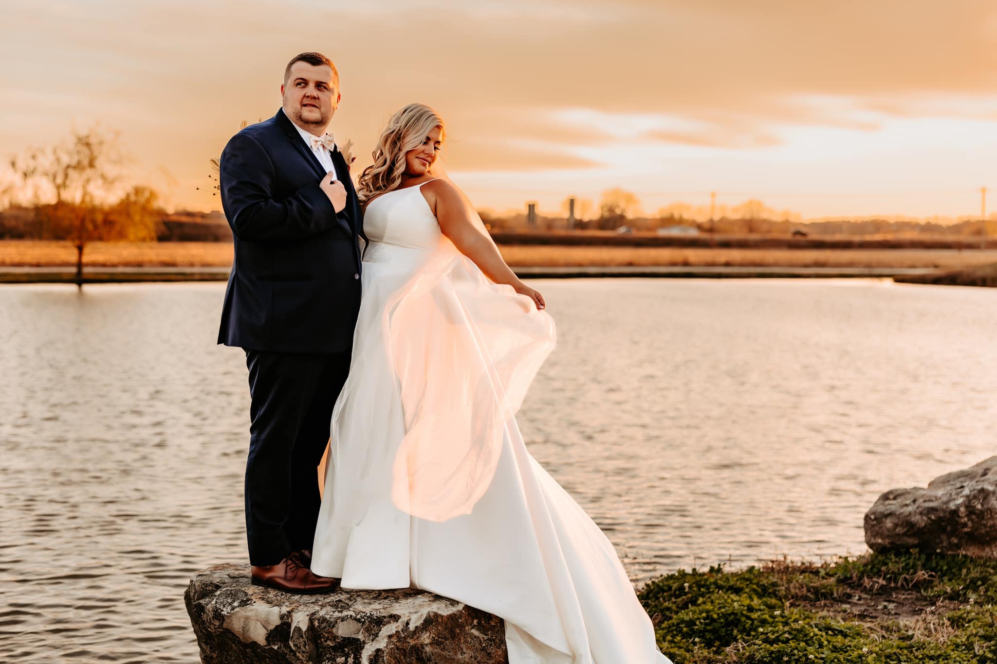 bride and groom next to pond at sunset