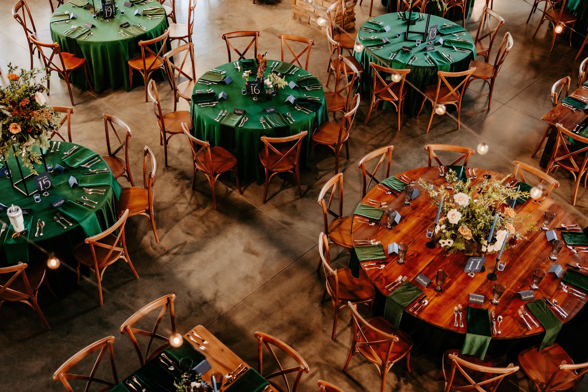 wedding reception with green table linens and wooden tables