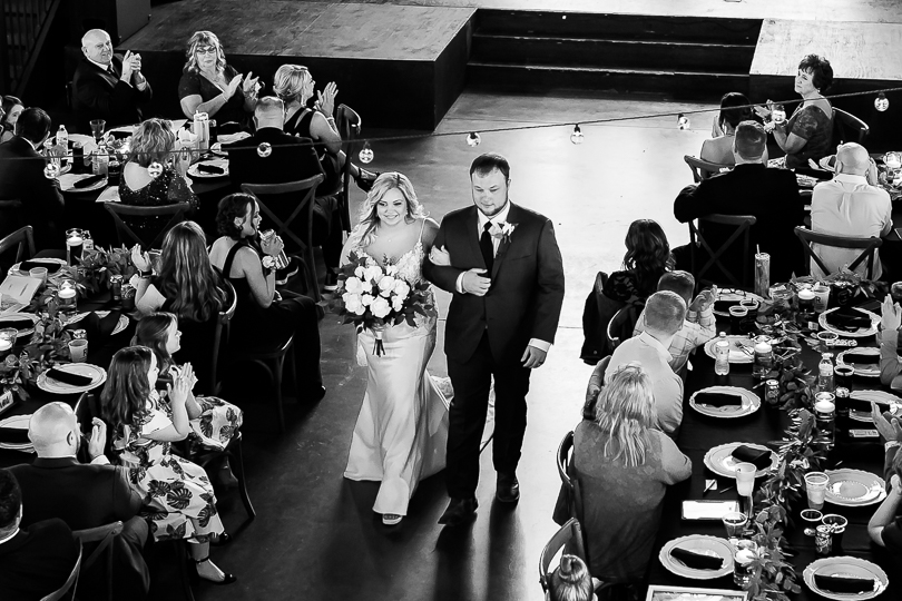 bride and groom walking into wedding reception