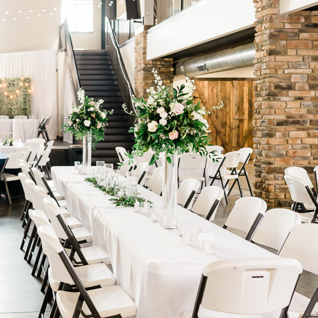 wedding reception table with tall white floral centerpieces