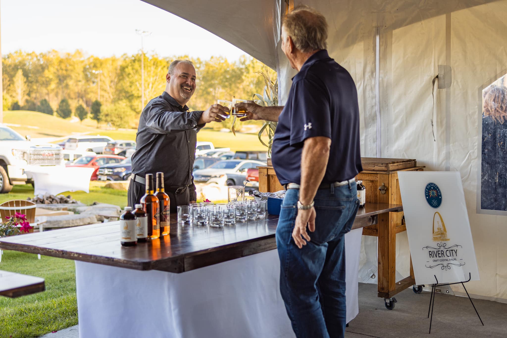 two men making toast at event