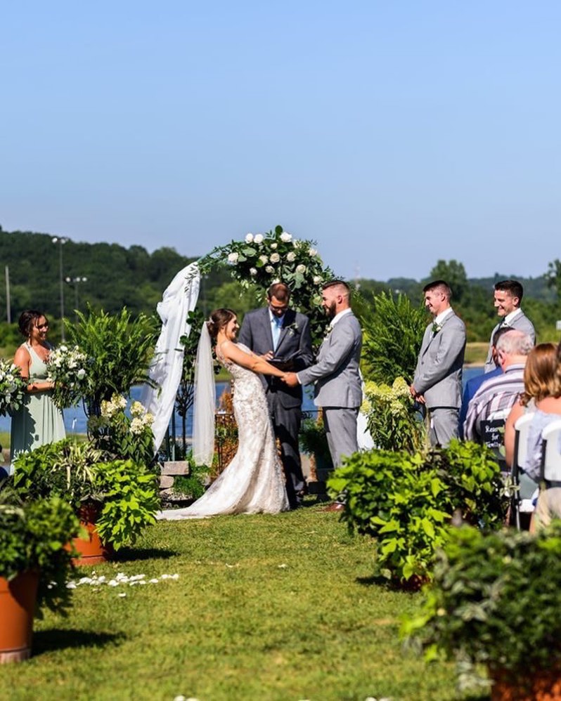 bride and groom holding hands at outdoor wedding ceremony